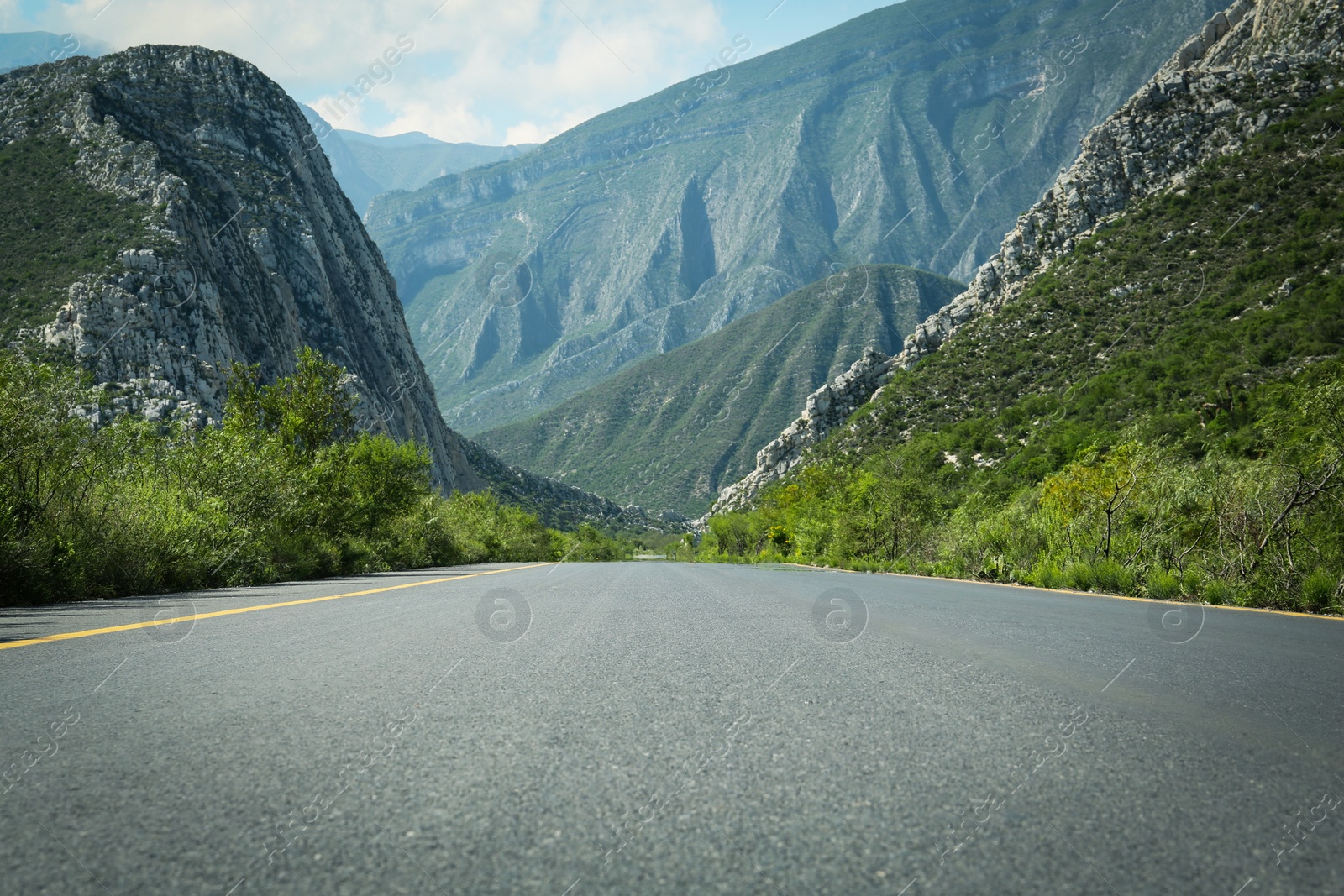 Photo of Picturesque view of big mountains and bushes near road