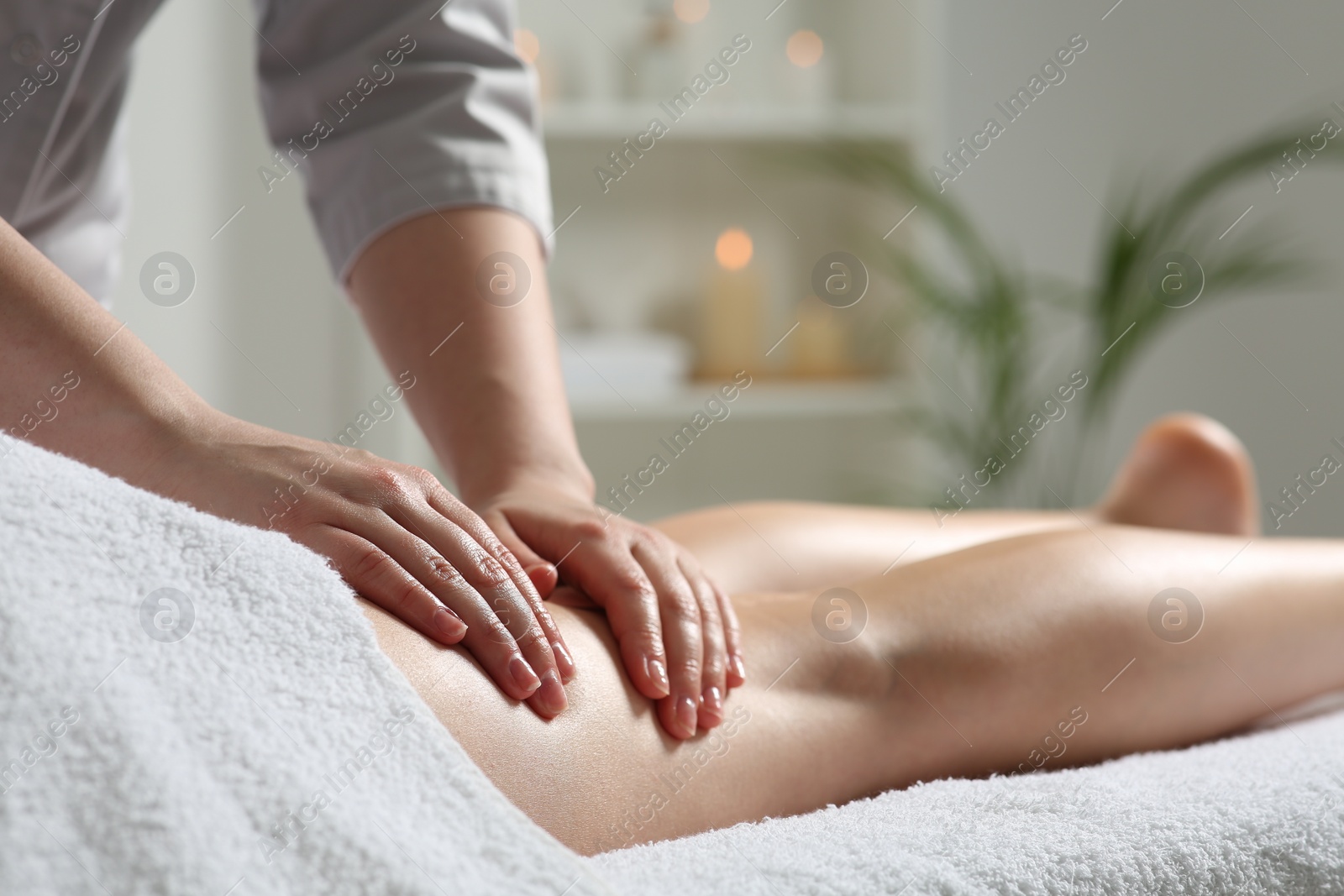 Photo of Woman receiving leg massage in spa salon, closeup