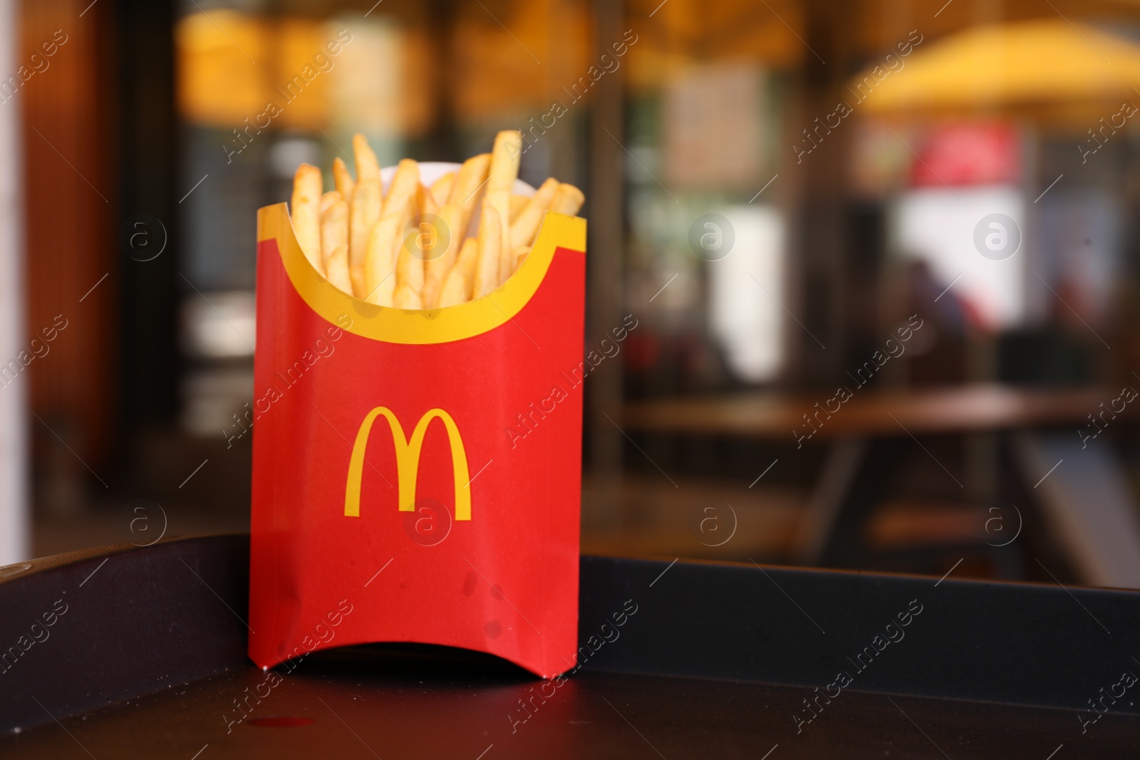 Photo of MYKOLAIV, UKRAINE - AUGUST 11, 2021: Big portion of McDonald's French fries on tray in cafe. Space for text