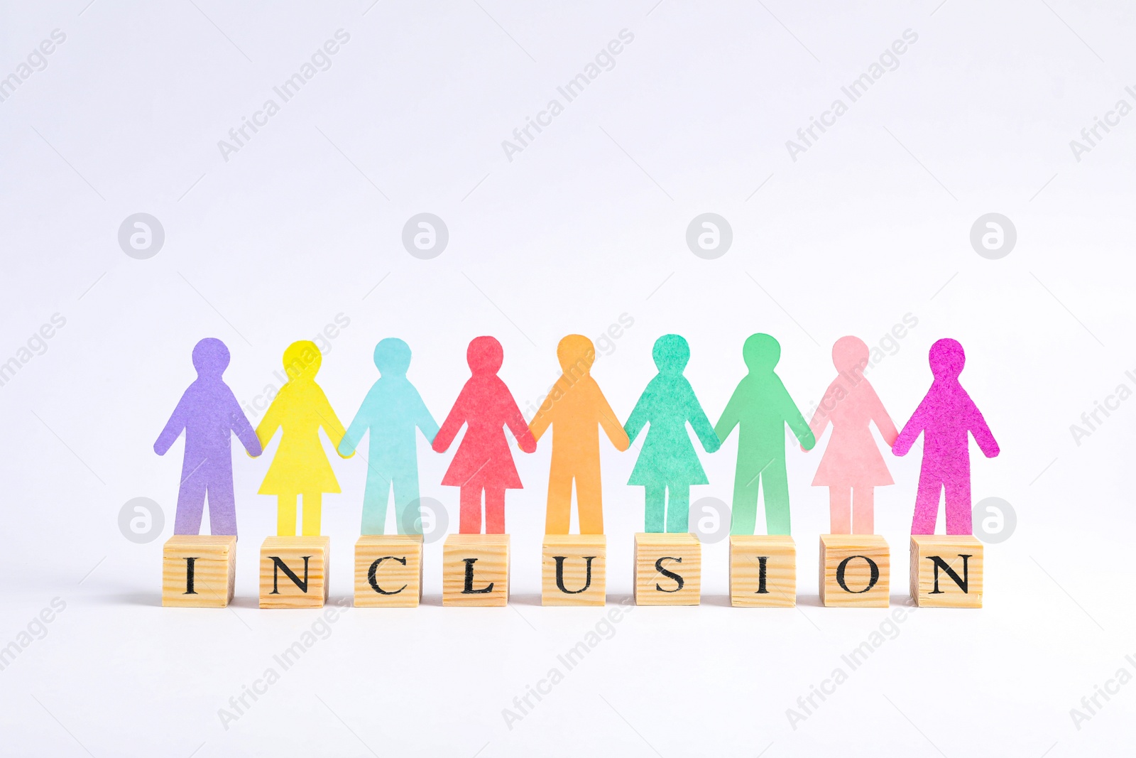 Photo of Paper human figures and wooden cubes with word Inclusion on white background