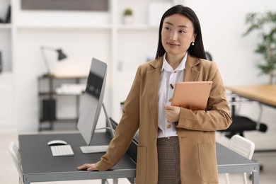 Photo of Portrait of beautiful businesswoman with tablet in office. Space for text