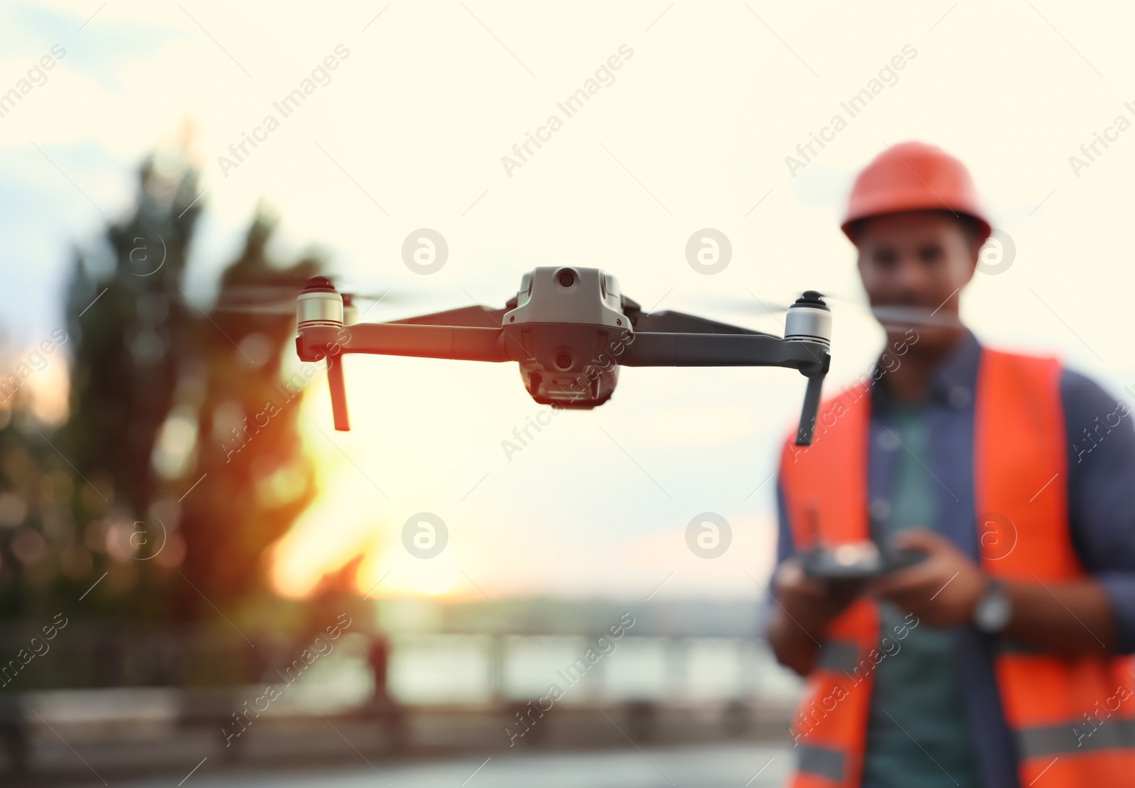 Photo of Builder operating drone with remote control at construction site, focus on quadcopter. Aerial survey