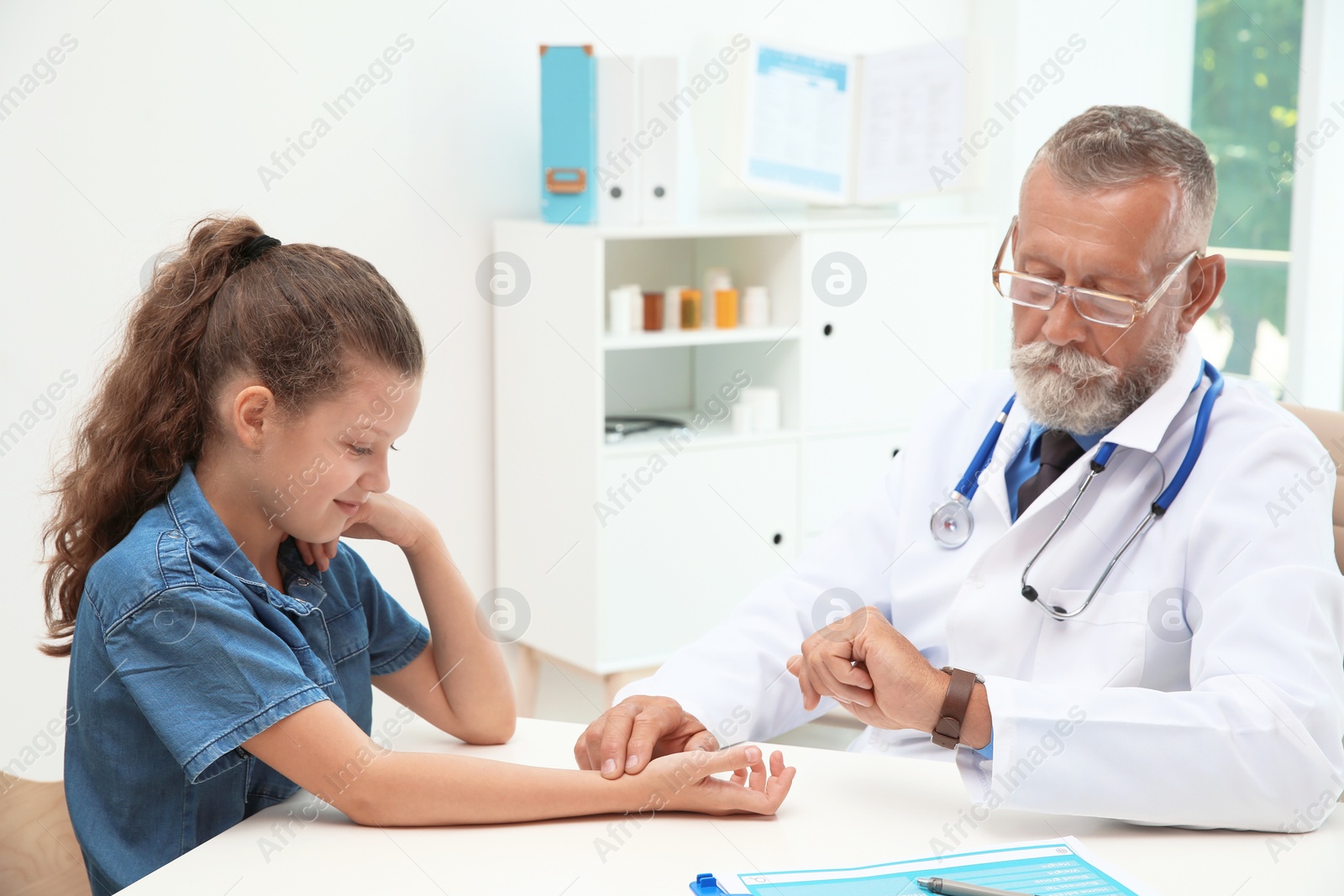 Photo of Doctor checking little girl's pulse in hospital