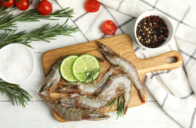 Photo of Flat lay composition with raw shrimps on white wooden table