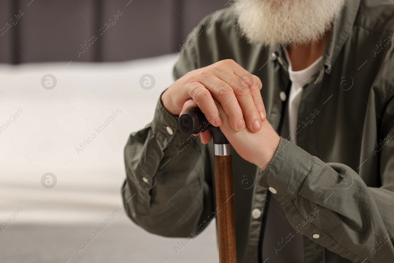 Photo of Senior man with walking cane indoors, closeup