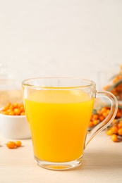 Photo of Delicious sea buckthorn tea on wooden table