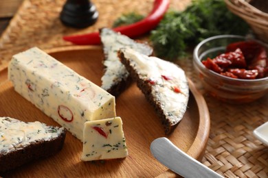 Photo of Tasty butter, dill, chili peppers and rye bread on table, closeup