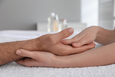 Man receiving hand massage in wellness center, closeup