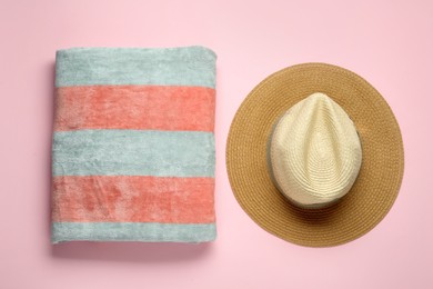 Photo of Beach towel and hat on pink background, flat lay