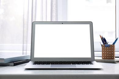 Modern computer with blank screen on table at workplace. Space for design