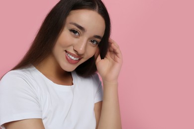 Portrait of beautiful young woman with elegant makeup on pink background. Space for text