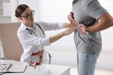 Photo of Gastroenterologist examining patient with stomach pain in clinic