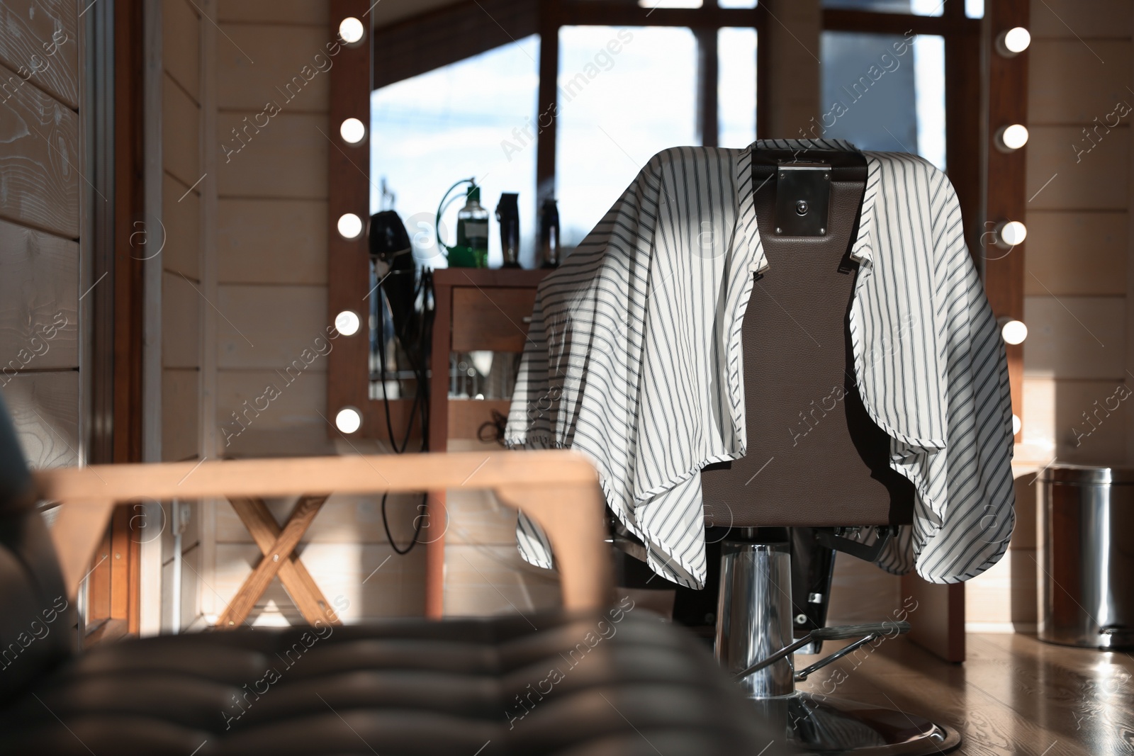 Photo of Stylish hairdresser's workplace with professional armchair in barbershop