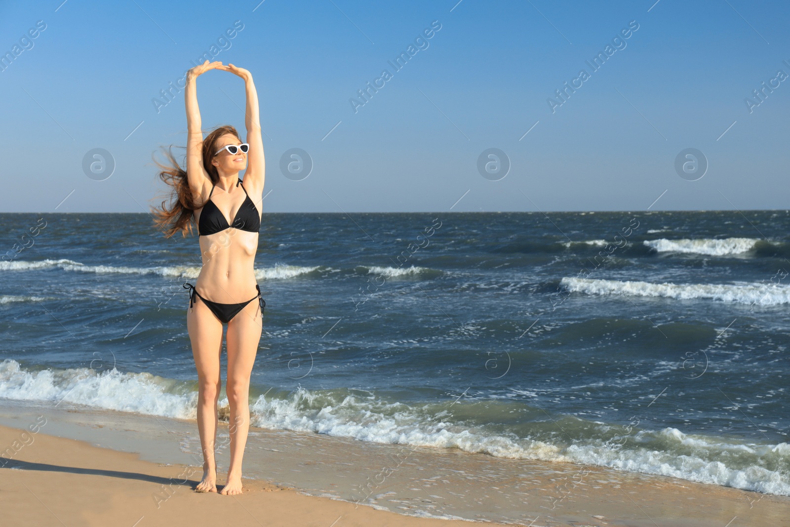 Photo of Beautiful woman in bikini on sea coast. Space for text