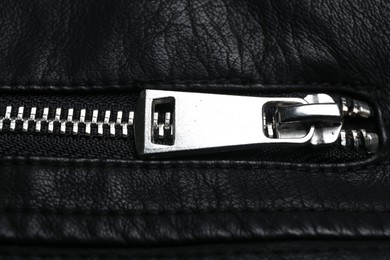 Photo of Closeup view of black leather jacket with zipper as background