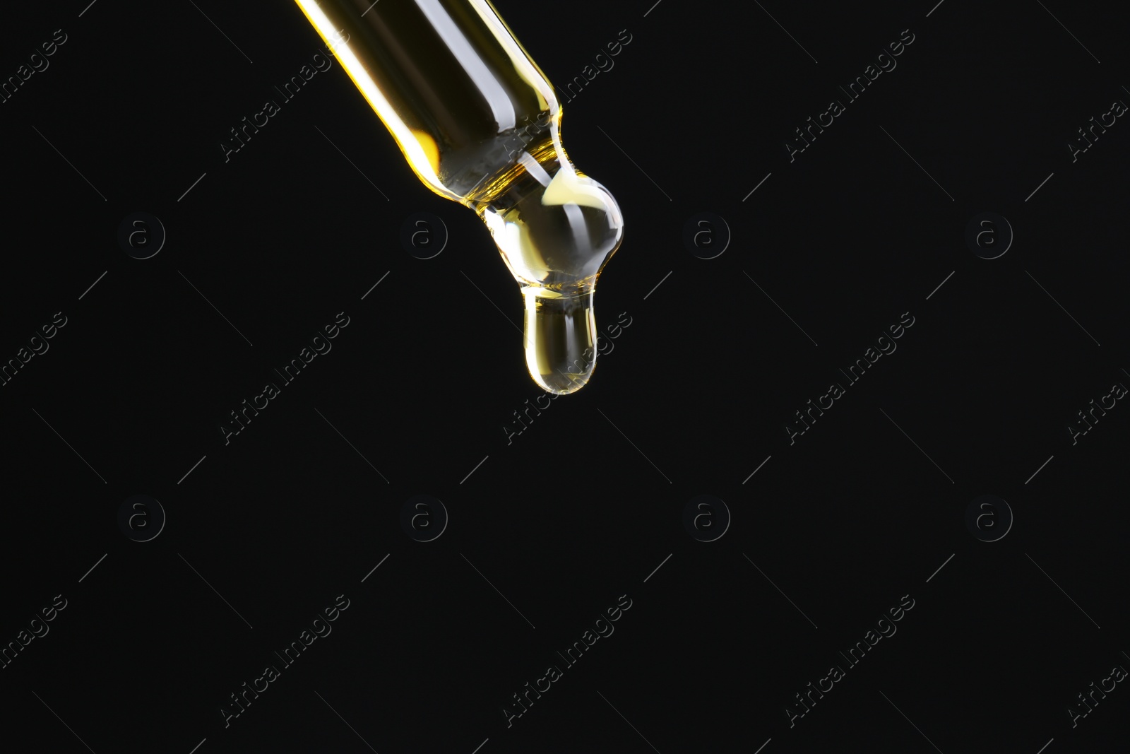 Photo of Dripping tincture from pipette on black background, closeup. Space for text