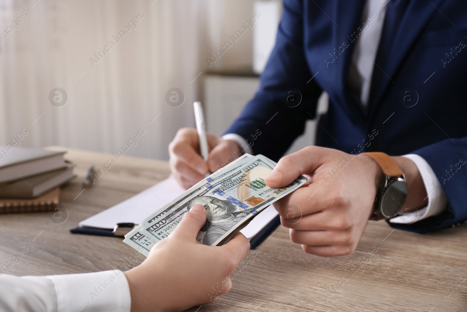 Photo of Woman giving bribe to man at table in office, closeup