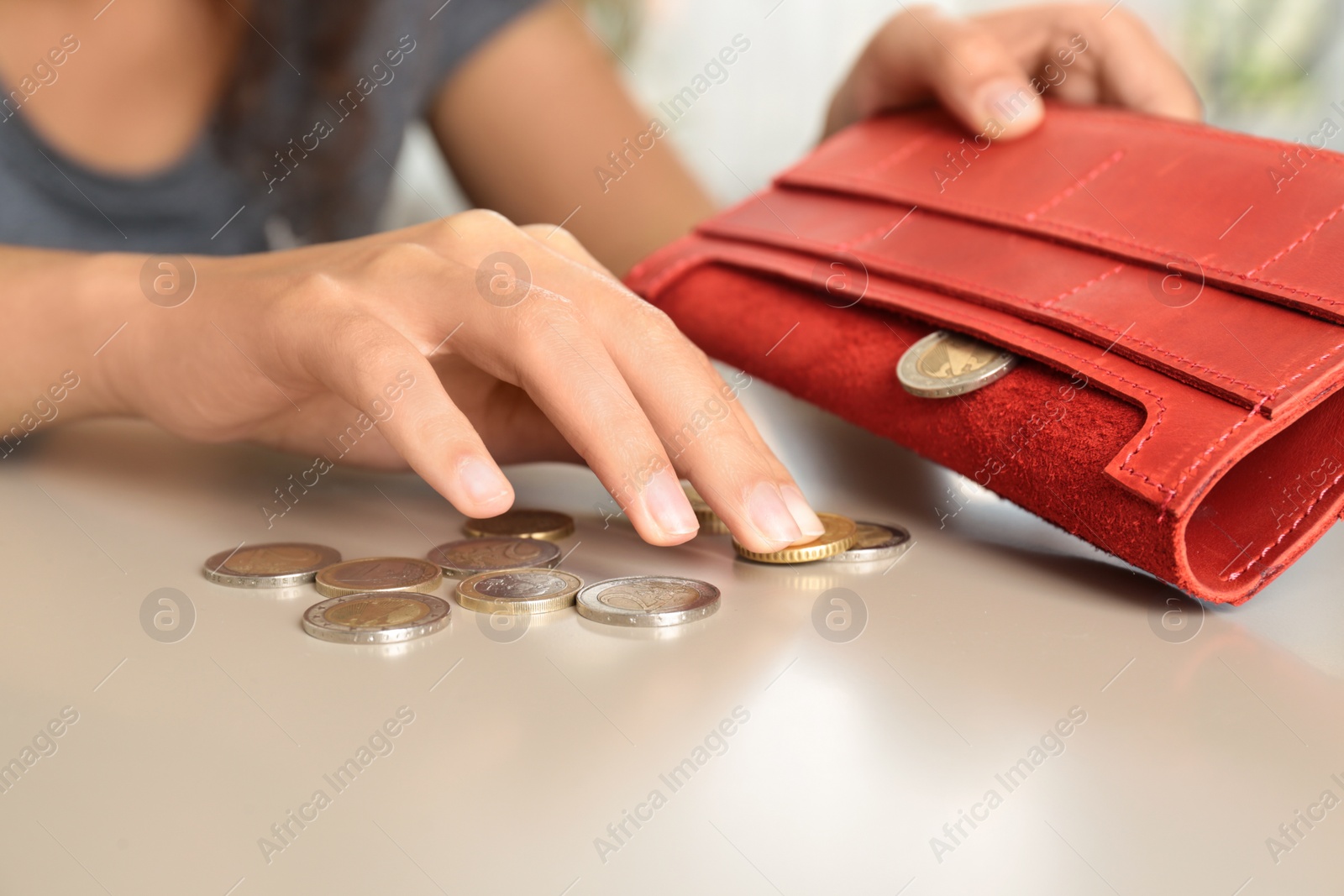 Photo of Young woman with coins and wallet at table, closeup