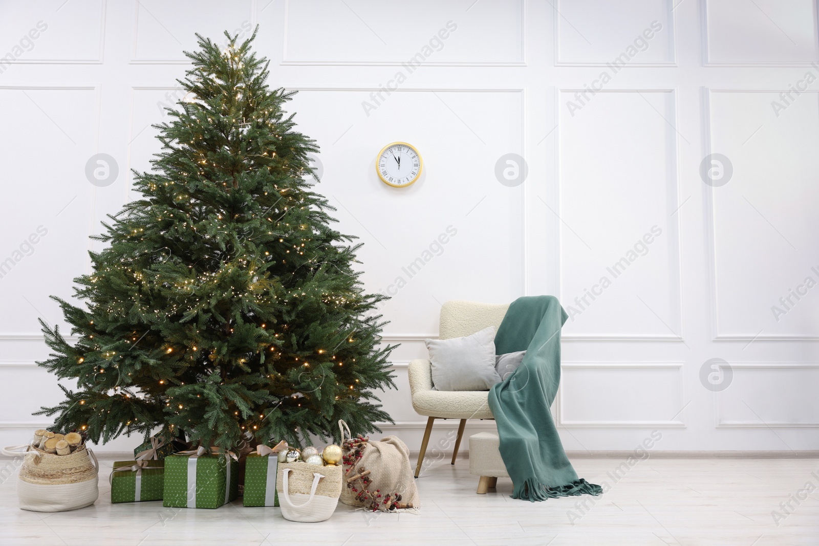 Photo of Many different gift boxes and firewood under Christmas tree indoors, space for text