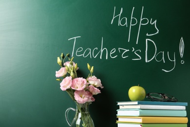 Photo of Vase of flowers and books near green chalkboard with inscription HAPPY TEACHER'S DAY