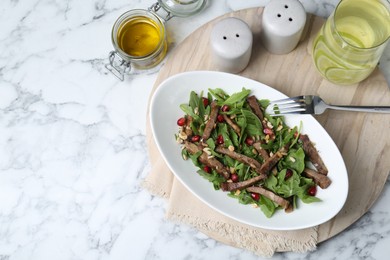 Delicious salad with beef tongue, arugula, seeds and fork served on white marble table, flat lay. Space for text
