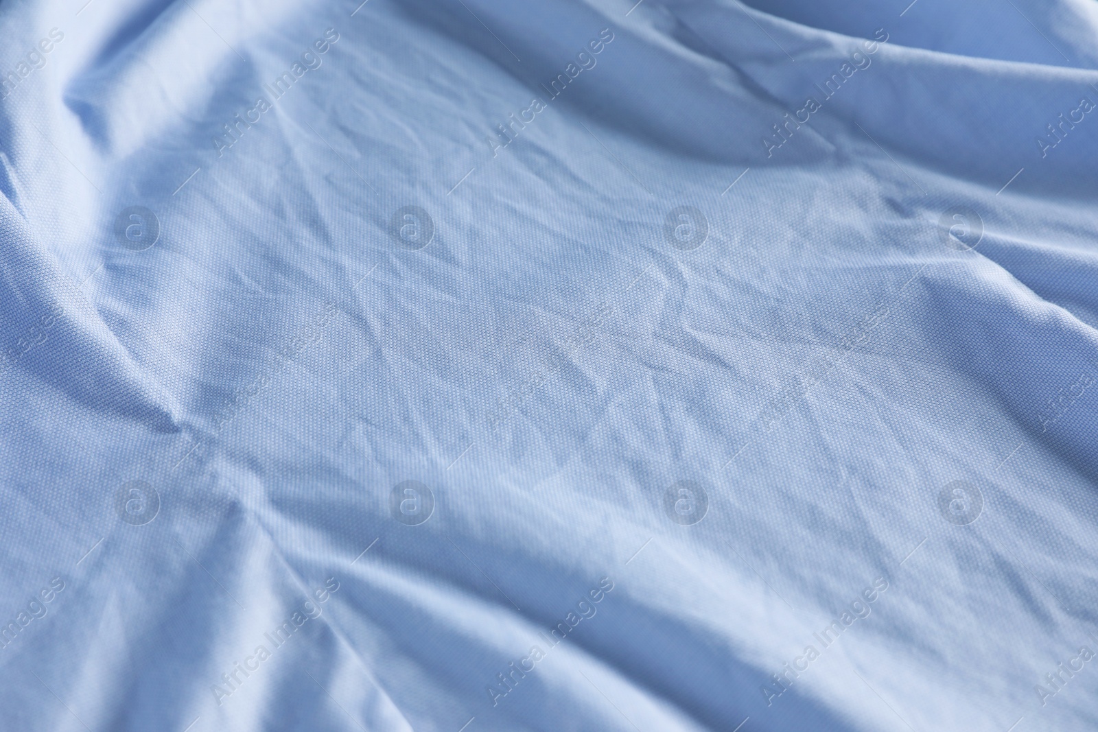 Photo of Crumpled light blue fabric as background, closeup view