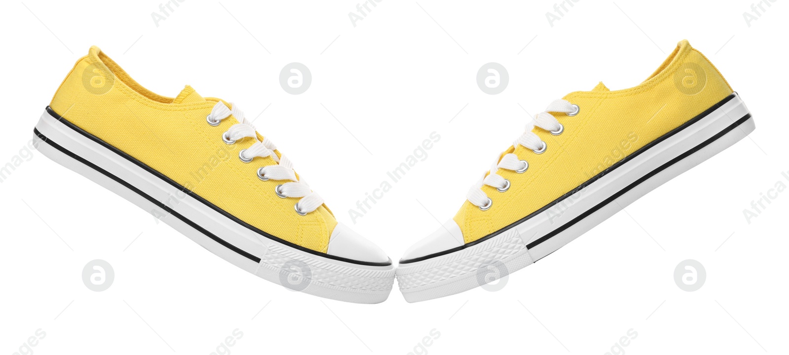 Photo of Pair of yellow classic old school sneakers on white background