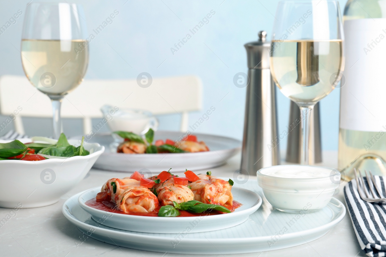 Photo of Plate with stuffed cabbage leaves in tomato sauce on table