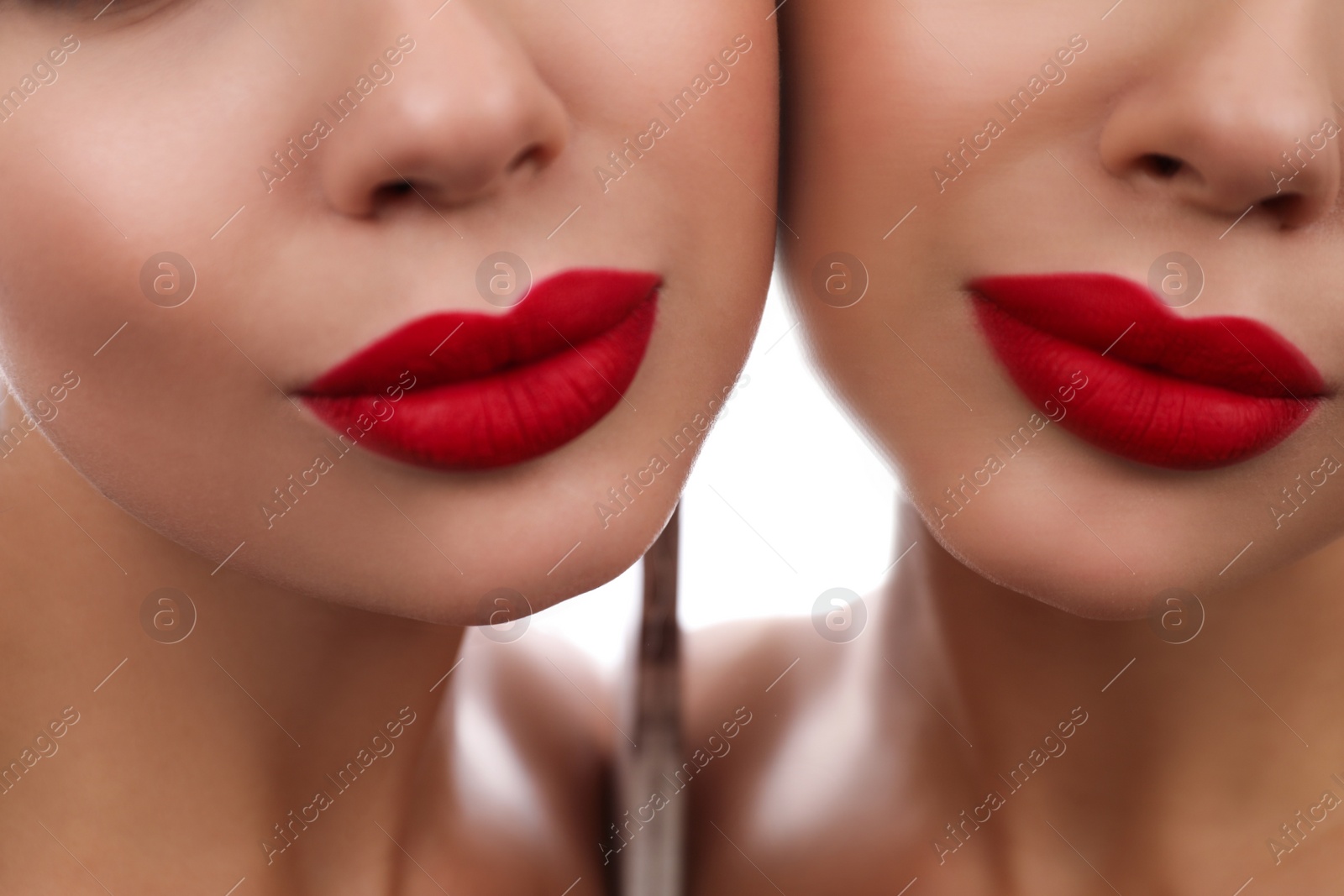 Photo of Beautiful woman with red lipstick near mirror, closeup