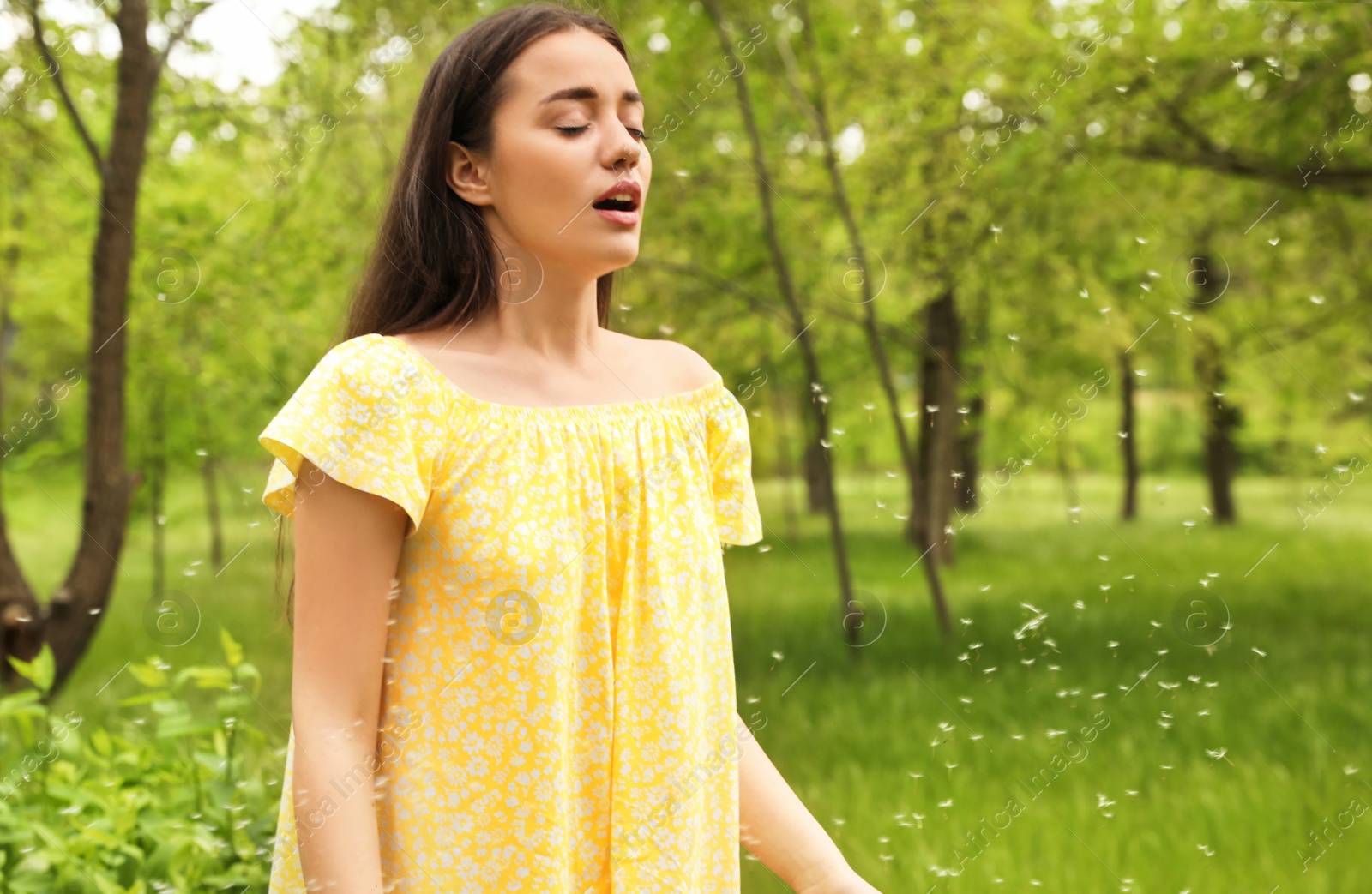 Photo of Young woman suffering from seasonal allergy outdoors, space for text