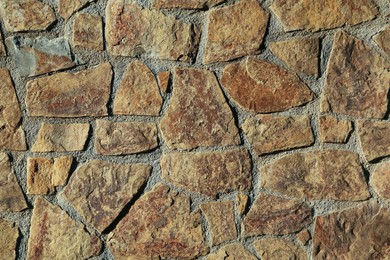 Photo of Texture of concrete wall decorated with stones as background, closeup