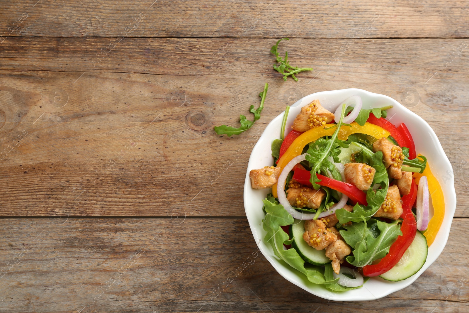 Photo of Delicious fresh chicken salad served on wooden table, flat lay. Space for text