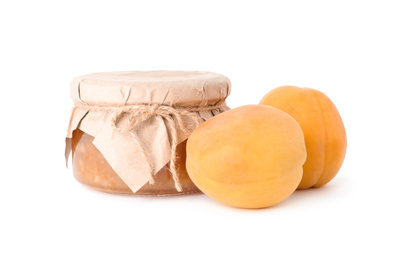 Jar of apricot jam and fresh fruits on white background
