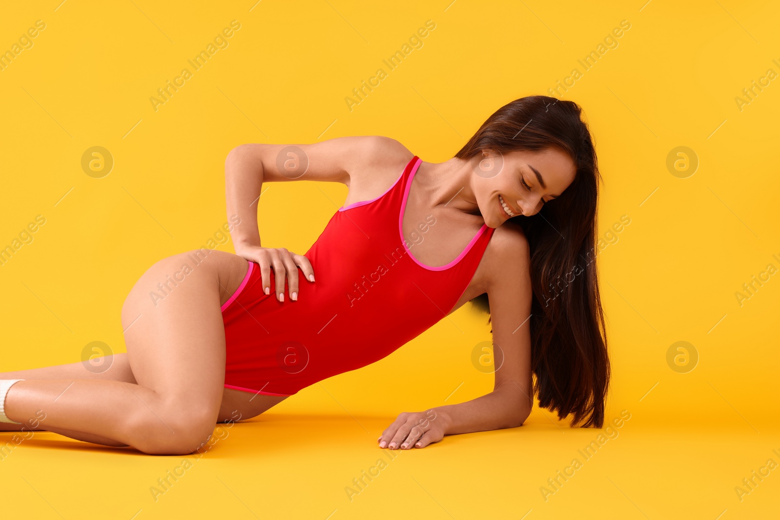 Photo of Young woman in stylish swimsuit on yellow background