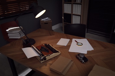 Photos, papers and typewriter on desk in office. Detective's workplace