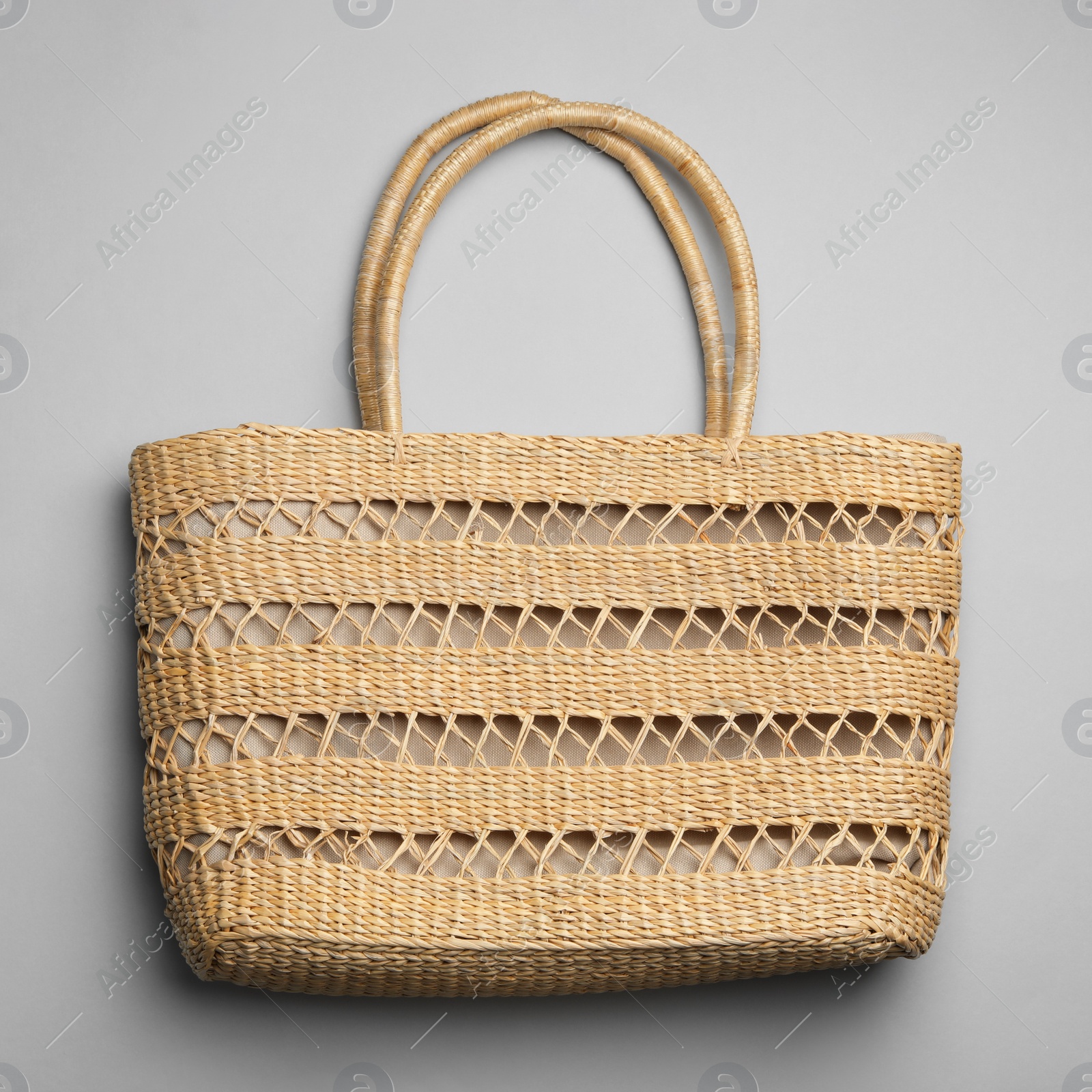 Photo of Stylish wicker woman's bag on light grey background, top view