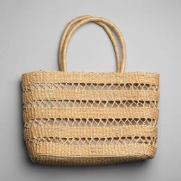 Stylish wicker woman's bag on light grey background, top view