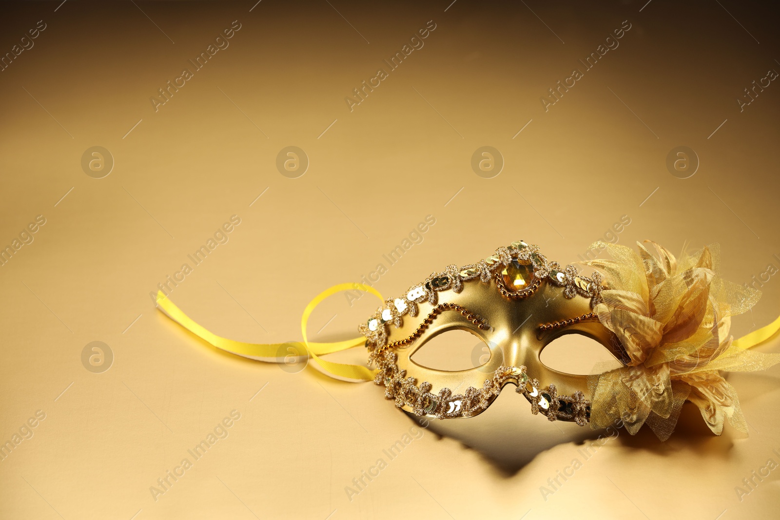 Photo of Beautifully decorated face mask on beige background, space for text. Theatrical performance