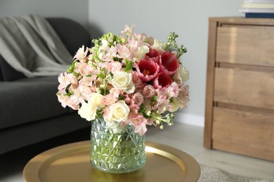 Beautiful bouquet of fresh flowers on coffee table in room