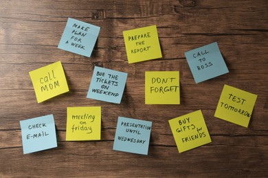 Photo of Paper notes with life-affirming phrases on wooden table, flat lay