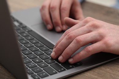 E-learning. Man using laptop during online lesson at table indoors, closeup