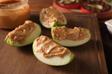 Photo of Slices of fresh apple with nut butter on wooden board