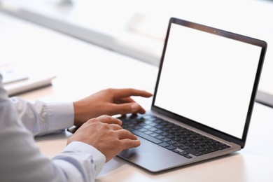 Photo of Man using modern laptop at white desk, closeup