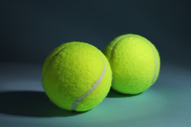 Two tennis balls on dusty light blue background, closeup