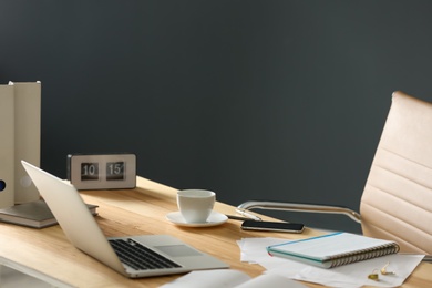 Modern laptop and supplies on table in office