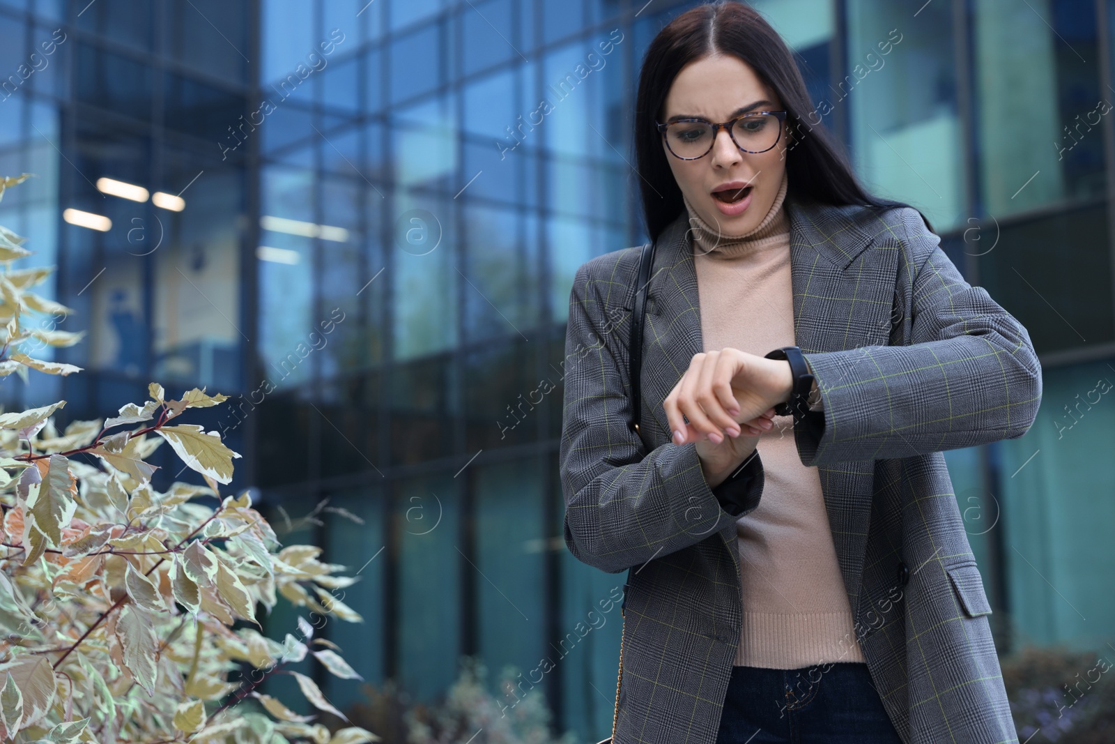 Photo of Emotional woman checking time on watch outdoors. Being late concept