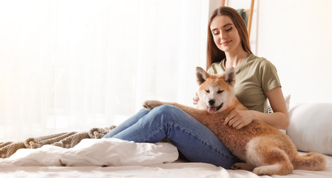 Image of Young woman with her cute Akita Inu dog at home, banner design. Lovely pet