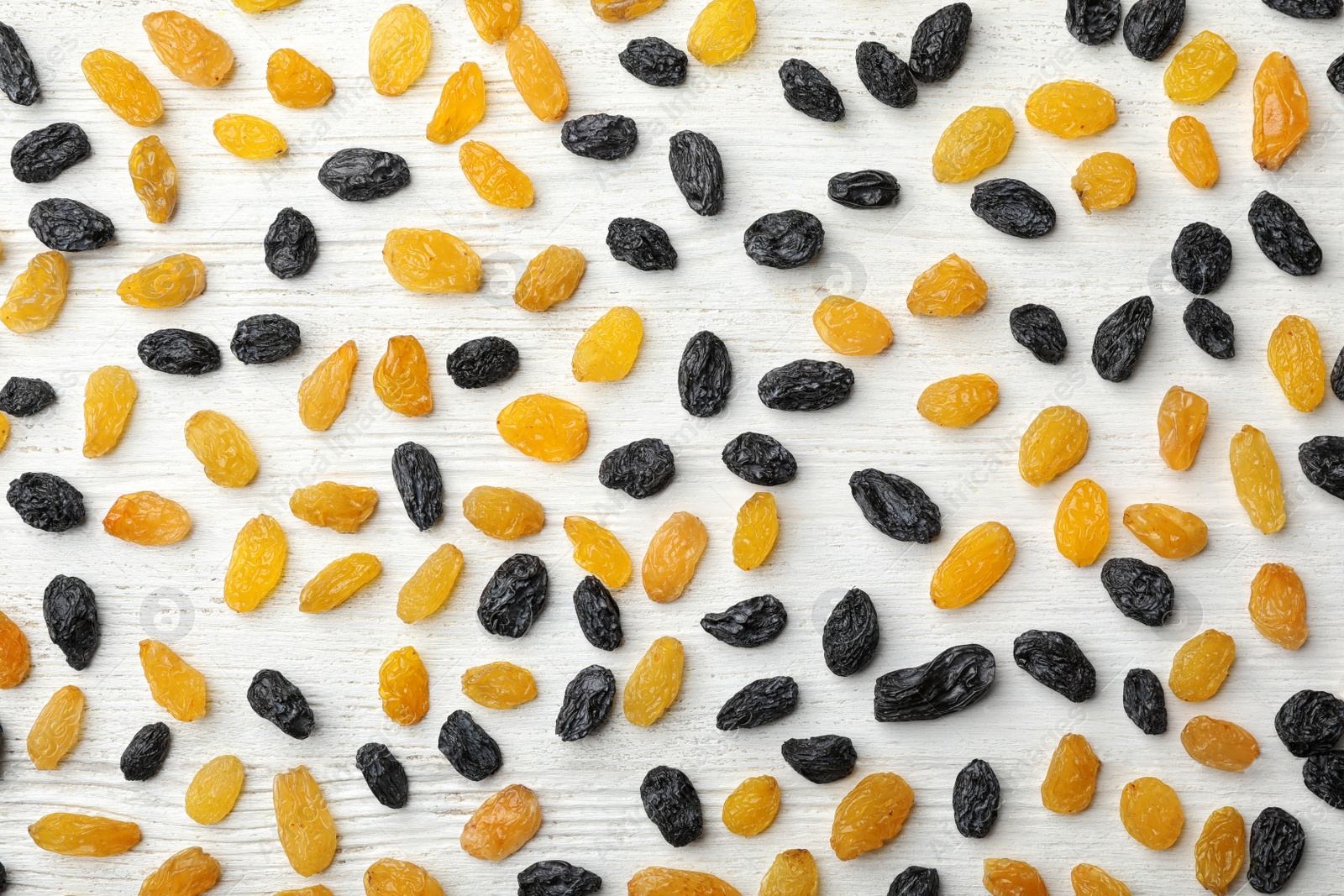 Photo of Flat lay composition with raisins on white wooden background. Dried fruit as healthy snack