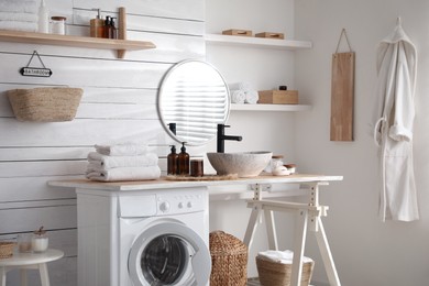 Stylish bathroom interior with modern washing machine