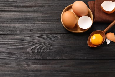 Chicken eggs on black wooden table, flat lay. Space for text